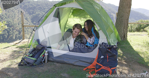 Image of Smiling couple having fun in tent