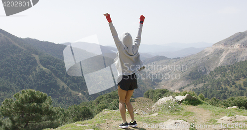 Image of Young successful boxer on top of mountain