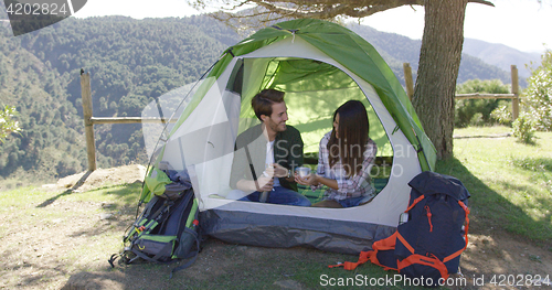 Image of Two people having rest in tent