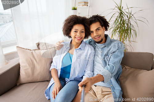 Image of happy couple with selfie stick at home