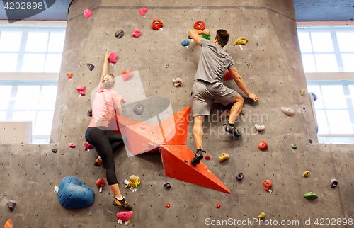 Image of man and woman exercising at indoor climbing gym