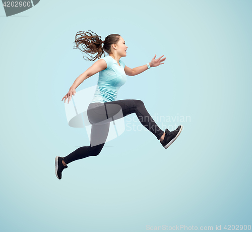 Image of happy smiling sporty young woman jumping in air