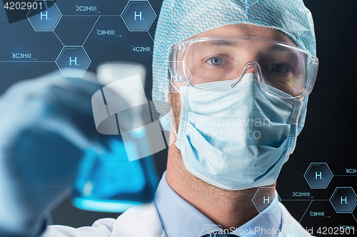 Image of close up of scientist holding flask with chemical