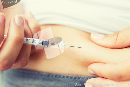 Image of woman with syringe making insulin injection