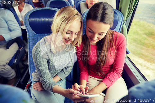 Image of happy young women in travel bus with smartphone