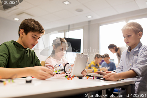 Image of kids with tablet pc programming at robotics school