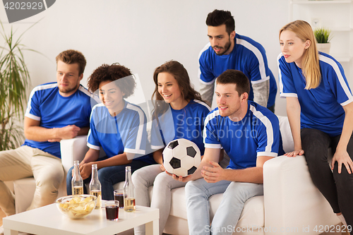 Image of friends or football fans watching soccer at home