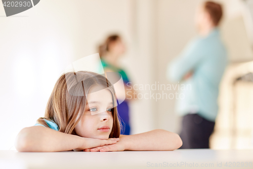 Image of beautiful sad girl and parents arguing at home