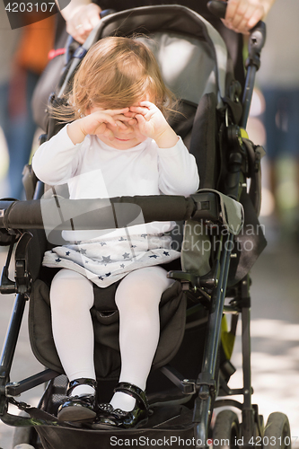 Image of baby girl sitting in the pram