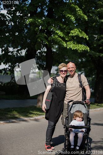 Image of couple with baby pram in summer park