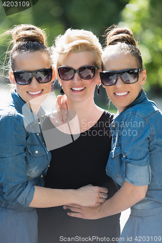 Image of portrait of three young beautiful woman with sunglasses