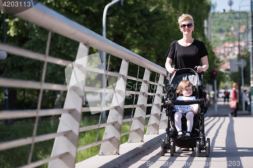 Image of mother pushed her baby daughter in a stroller