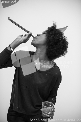 Image of black woman in party hat blowing in whistle