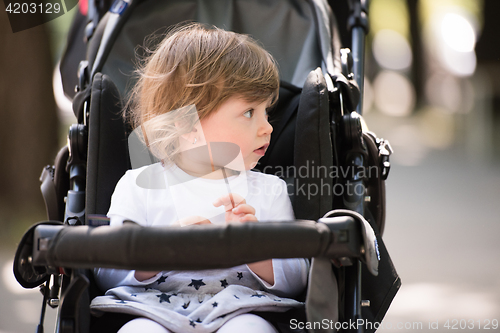 Image of baby girl sitting in the pram