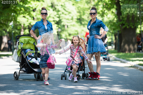 Image of twins mother with children  in city park