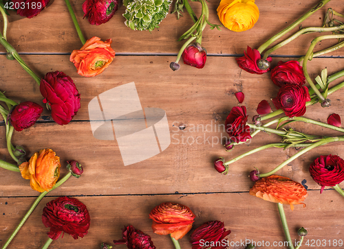 Image of Ranunkulyus bouquet of red flowers on a wooden background