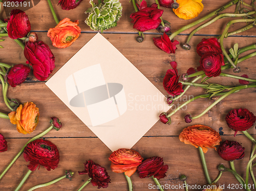 Image of Ranunkulyus bouquet of red flowers on a wooden background