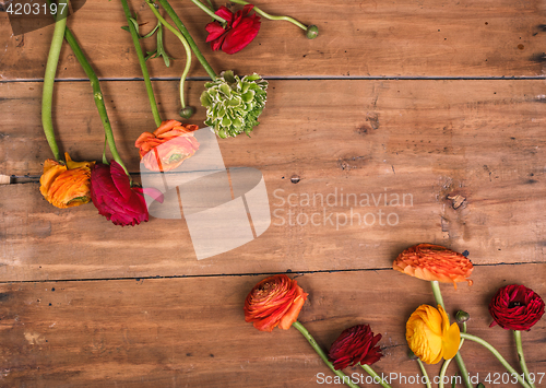 Image of Ranunkulyus bouquet of red flowers on a wooden background