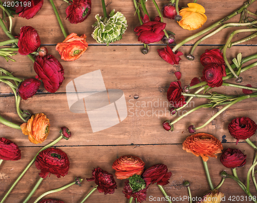 Image of Ranunkulyus bouquet of red flowers on a wooden background