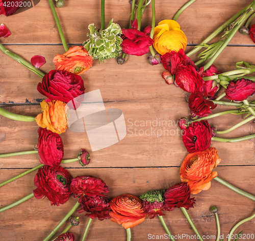 Image of Ranunkulyus bouquet of red flowers on a wooden background