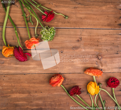 Image of Ranunkulyus bouquet of red flowers on a wooden background