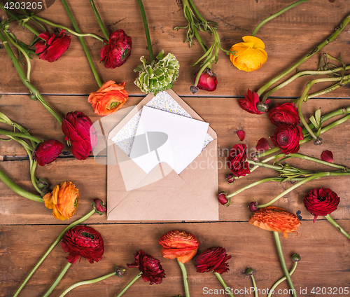 Image of Ranunkulyus bouquet of red flowers on a wooden background