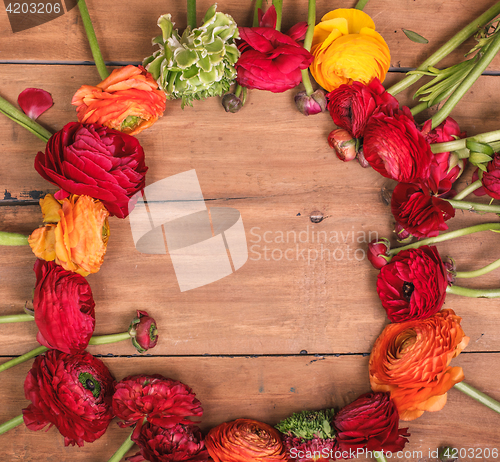 Image of Ranunkulyus bouquet of red flowers on a wooden background