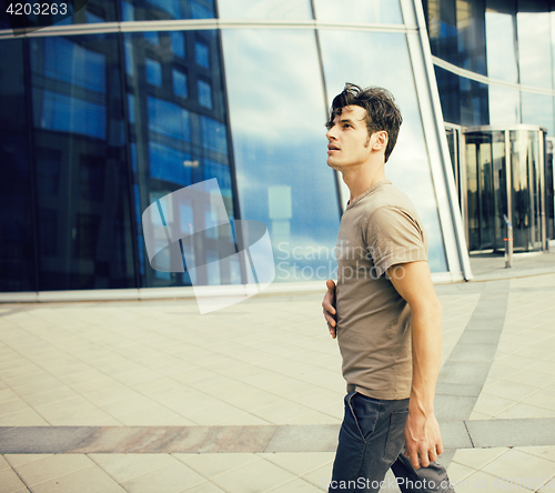 Image of real young man stand in front of modern business building