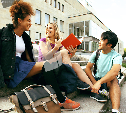 Image of cute group of teenages at the building of university with books 