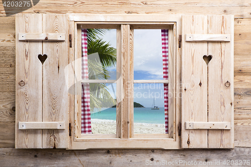 Image of Wooden window with sunny beach panorama view