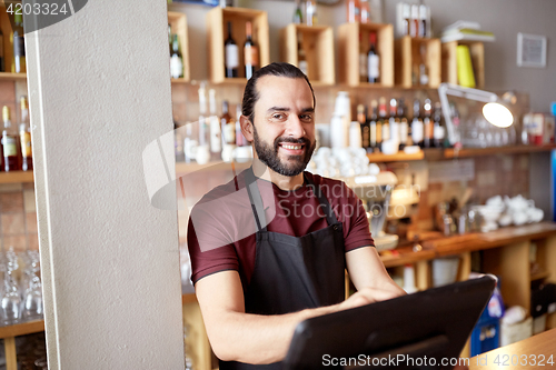 Image of happy man or waiter at bar cashbox