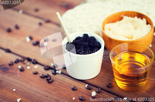 Image of close up of coffee scrub in cup and honey on wood