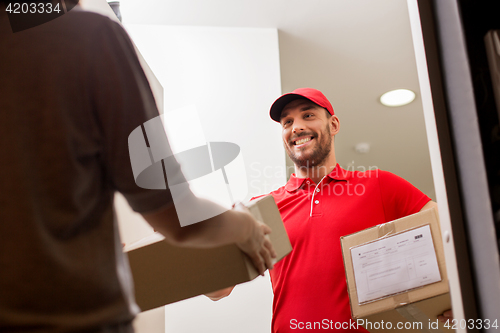 Image of happy delivery man giving parcel box to customer