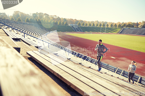 Image of happy couple running upstairs on stadium