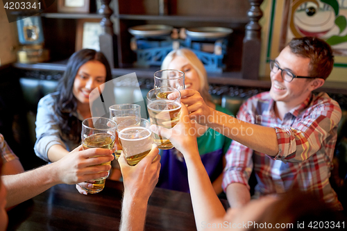 Image of happy friends drinking beer at bar or pub