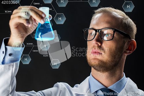 Image of young scientist holding test flask with chemical