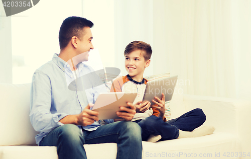 Image of happy father and son with tablet pc at home