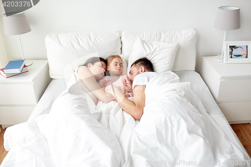 Image of happy family sleeping in bed at home