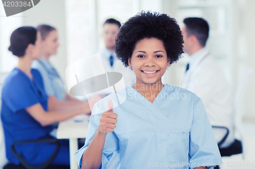 Image of happy doctor over group of medics at hospital