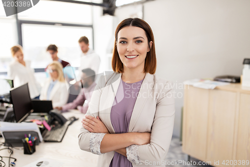 Image of happy young woman over creative team in office