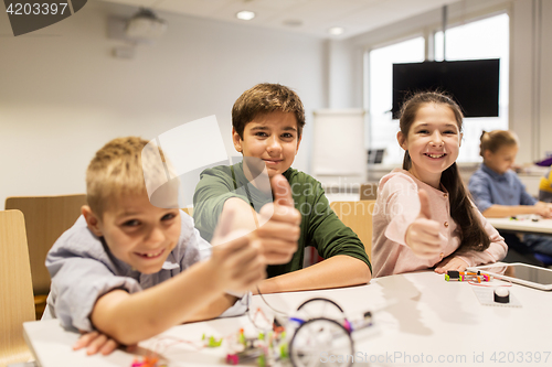 Image of happy children building robots at robotics school