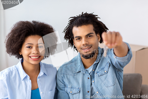 Image of happy couple with key and boxes moving to new home