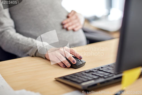 Image of pregnant businesswoman with computer at office