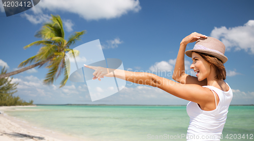 Image of happy young woman in hat on summer beach