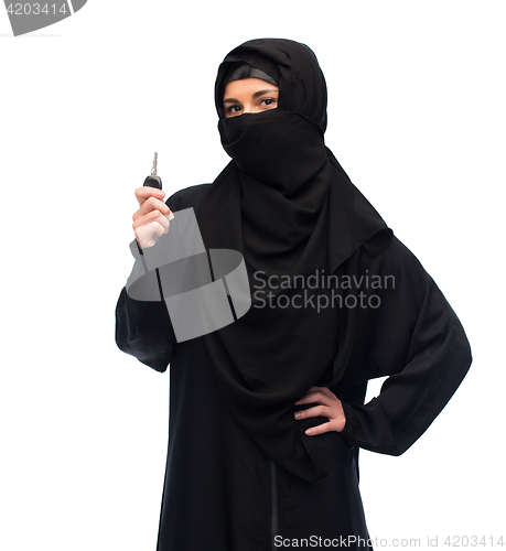 Image of muslim woman in hijab with car key over white