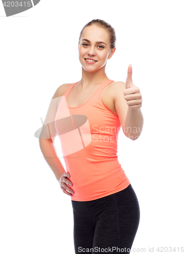 Image of happy sportive young woman showing thumbs up