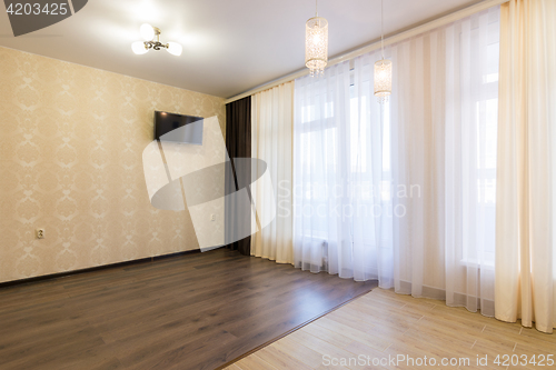 Image of The interior of an empty room in the newly renovated, with a large curtained window