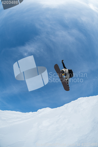 Image of Snowboarder jumping against blue sky