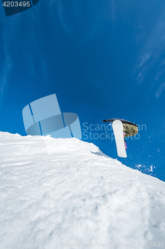 Image of Snowboarder jumping against blue sky