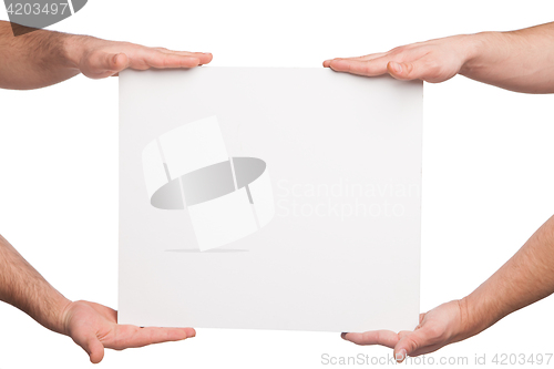 Image of four hands holding a blank white board